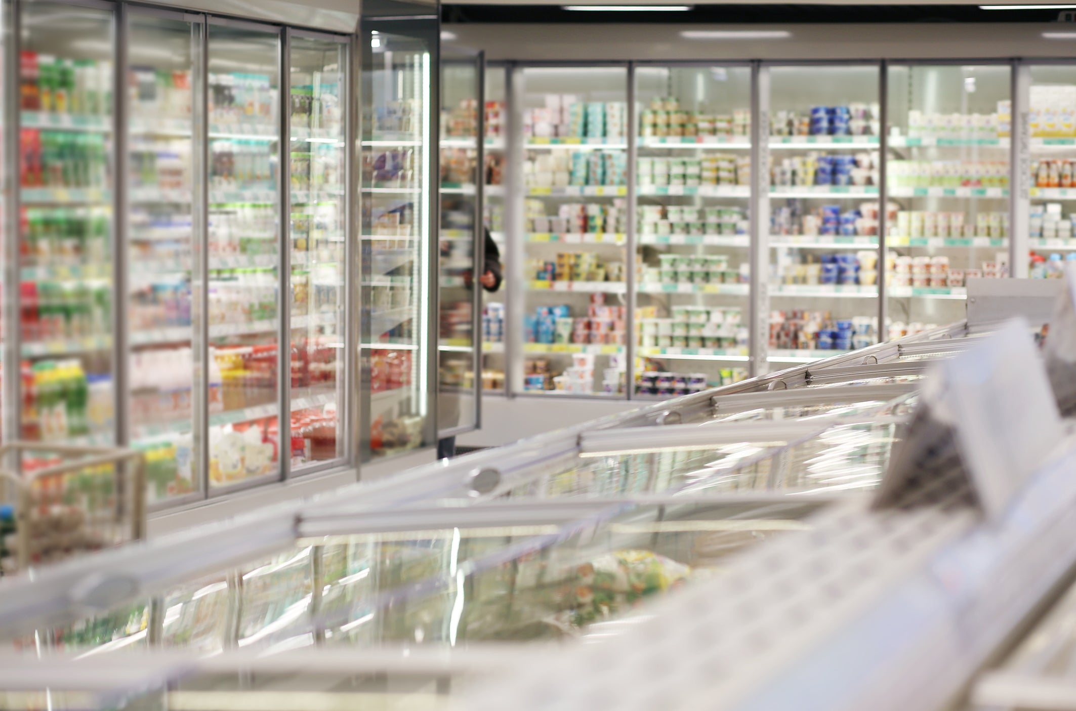 Supermarket refrigerated section with various products on shelves.