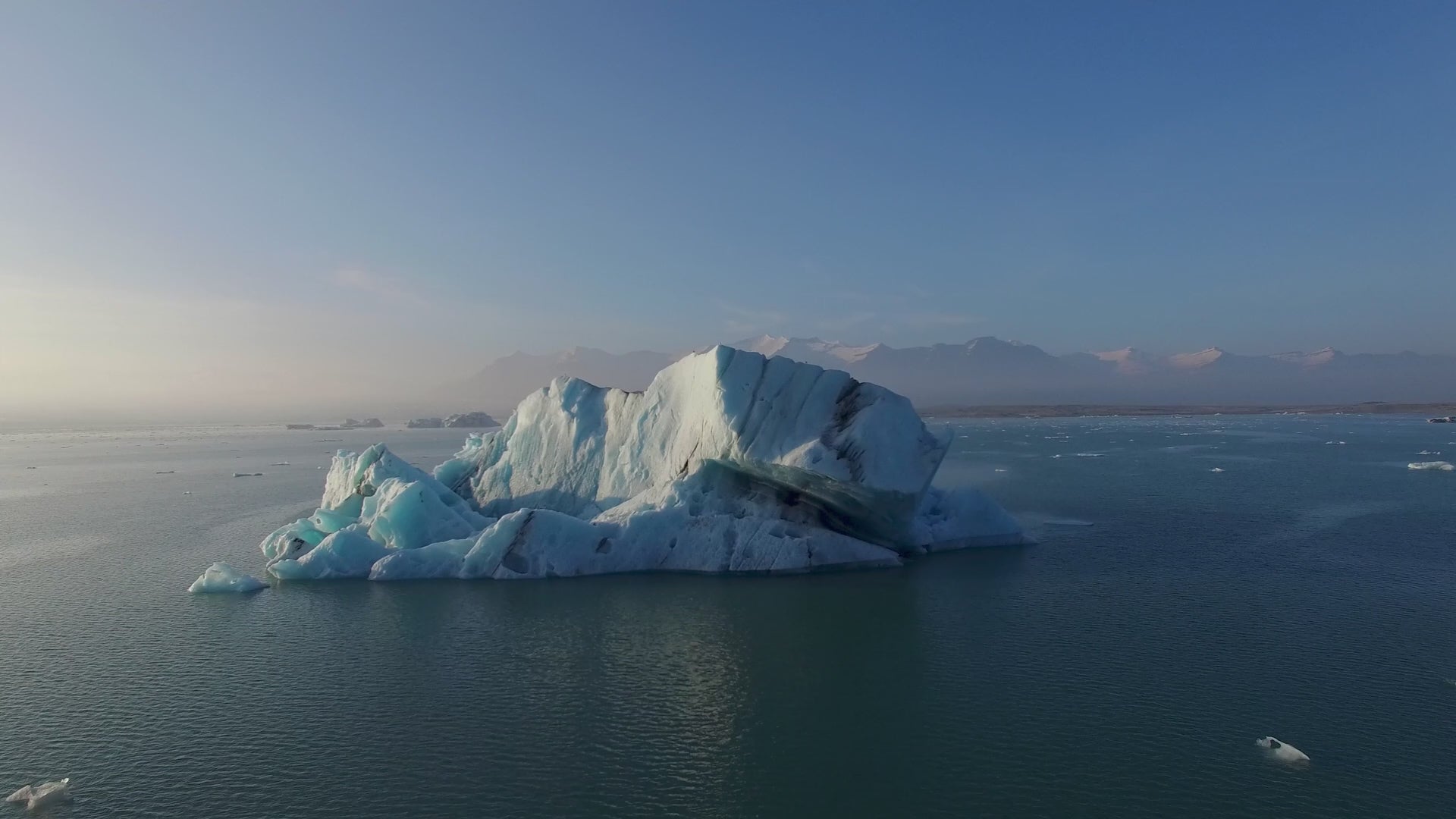 Load video: Climate change video, showing an iceberg melting in the ocean.