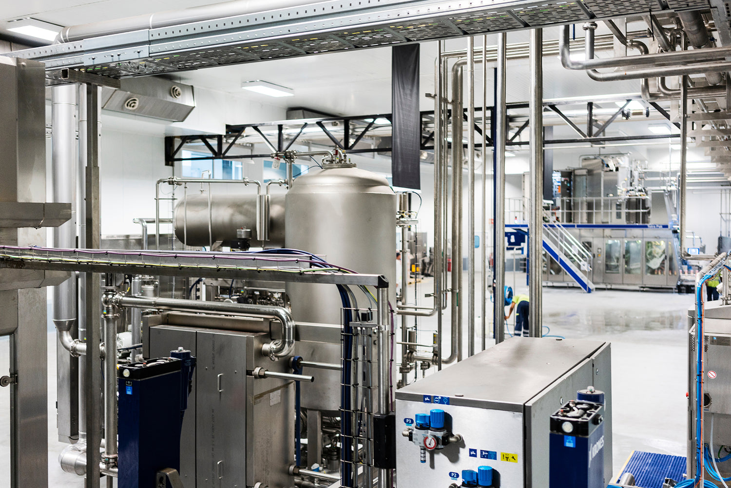 Industrial interior with large metallic equipment and pipes in a factory setting