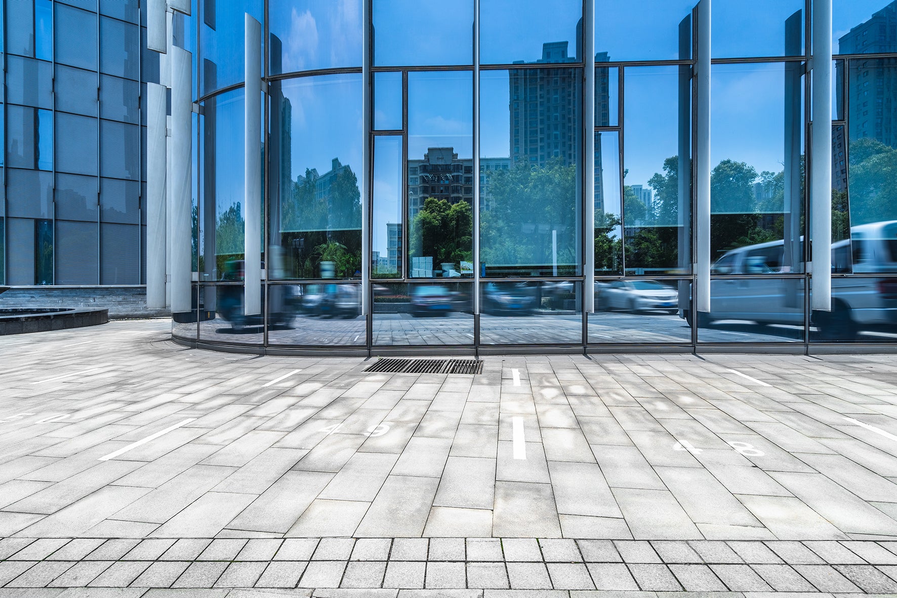 Modern glass building with reflective pavement