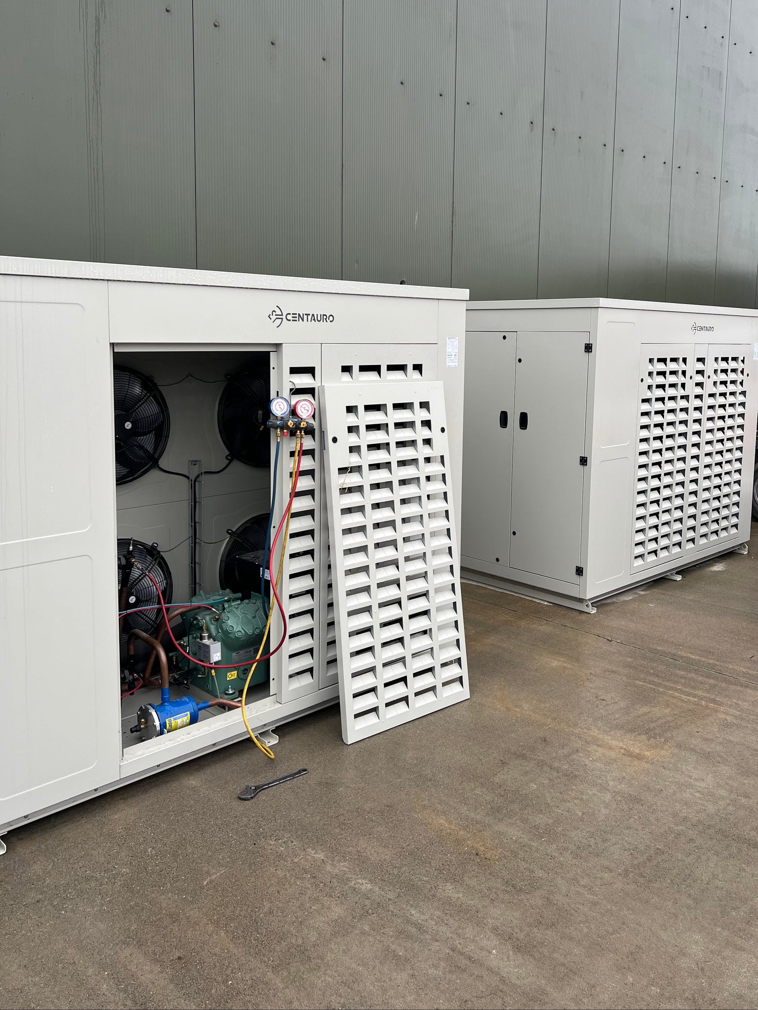 Two large industrial Centauro units with one open, revealing internal components, on a concrete floor.