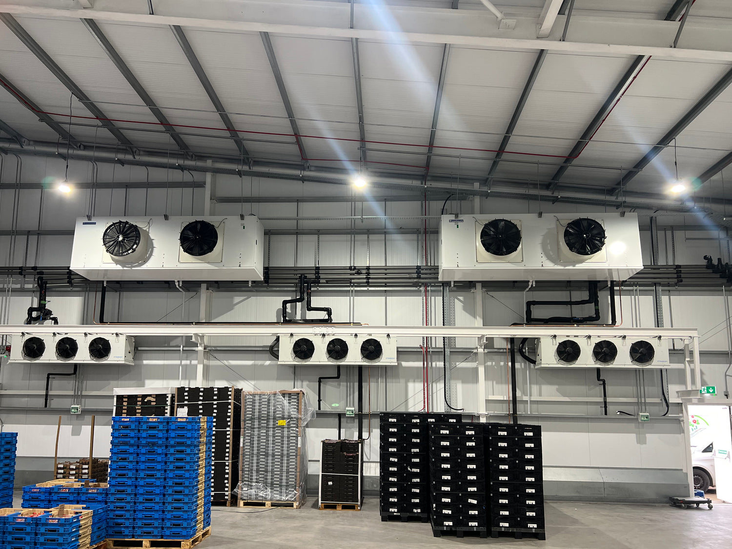Cold storage facility with refrigeration units and stacked pallets.