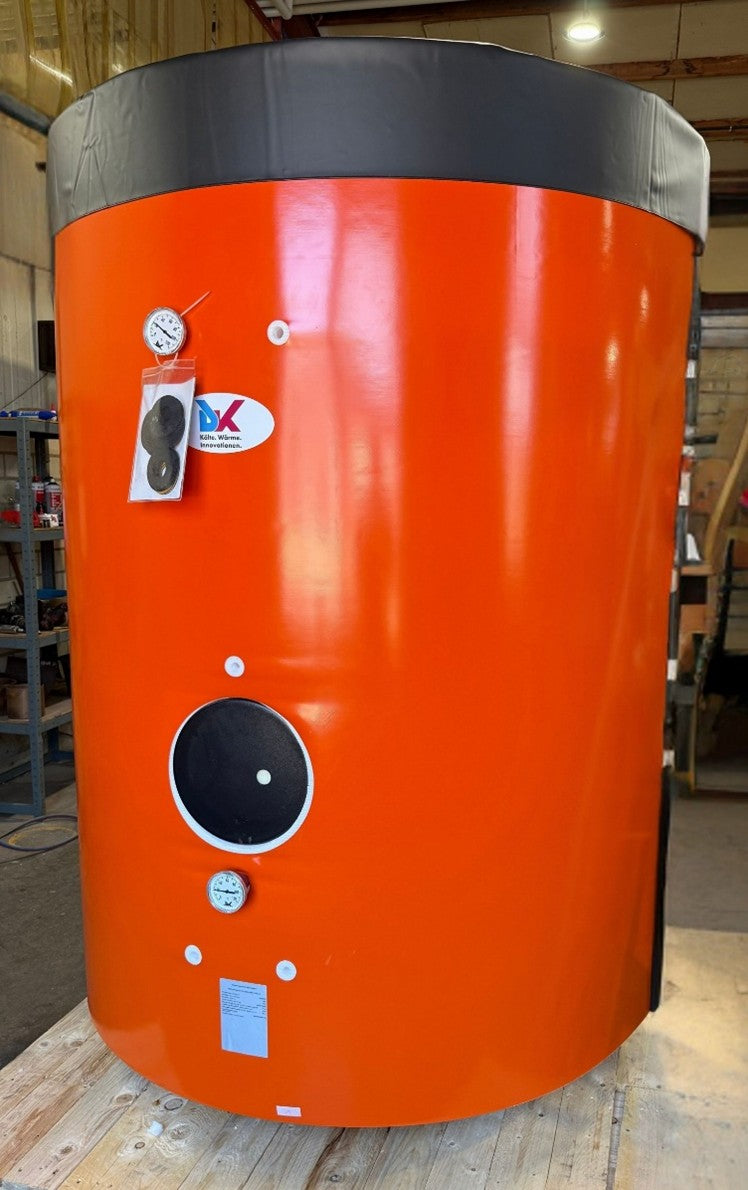 Large orange cylindrical tank with black top and bottom, featuring labels, in an indoor setting.