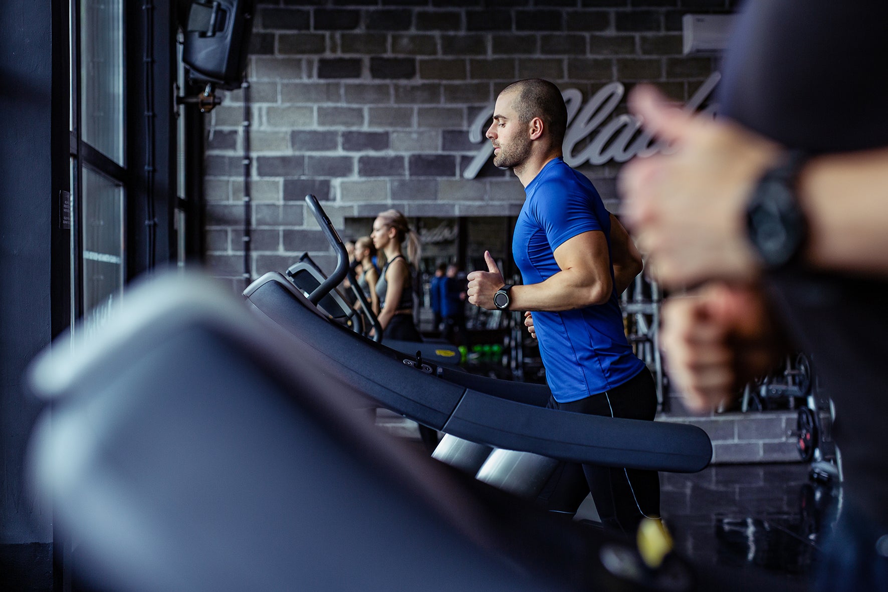 Man running on a treadmill in gym.