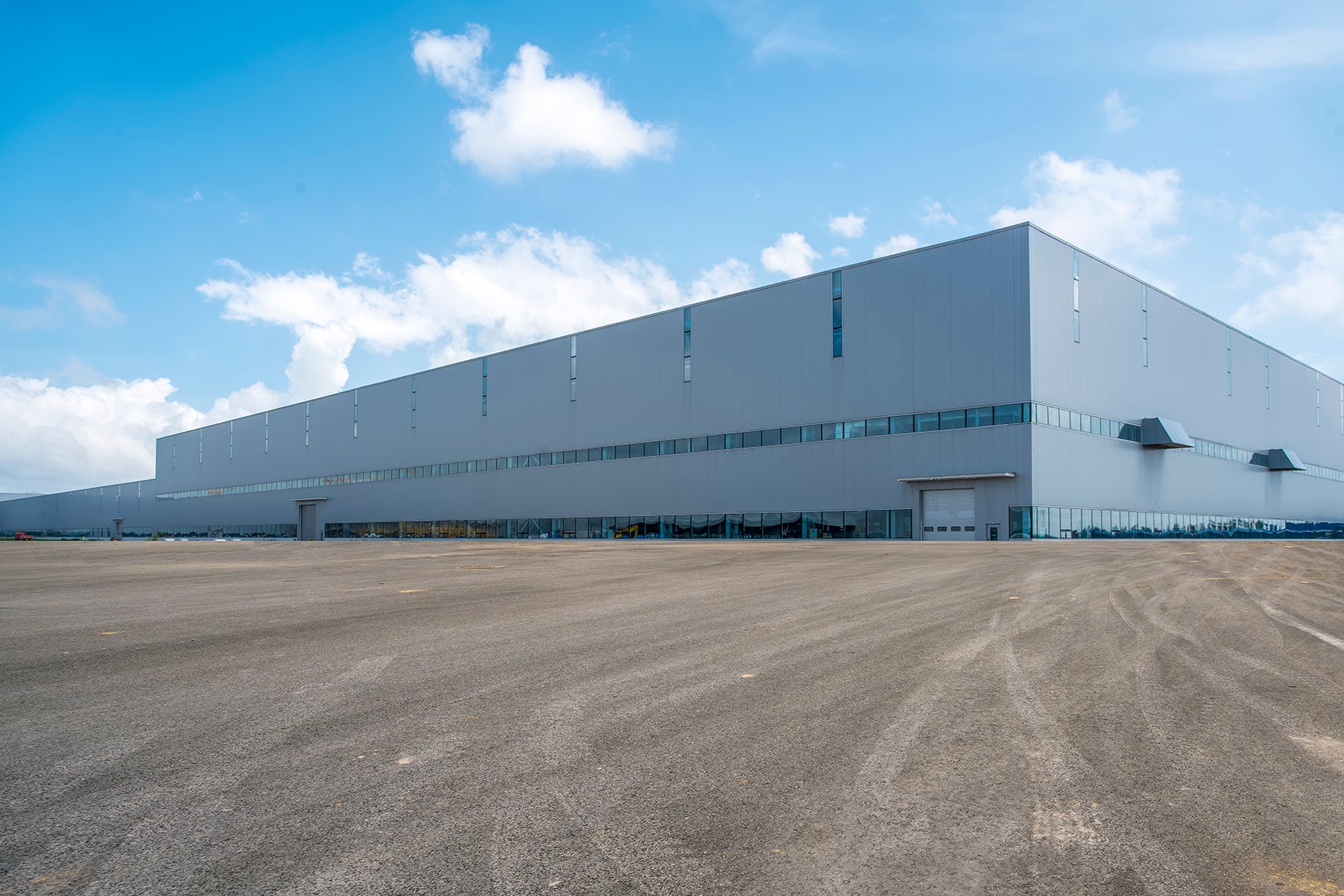 Large grey warehouse with blue sky.