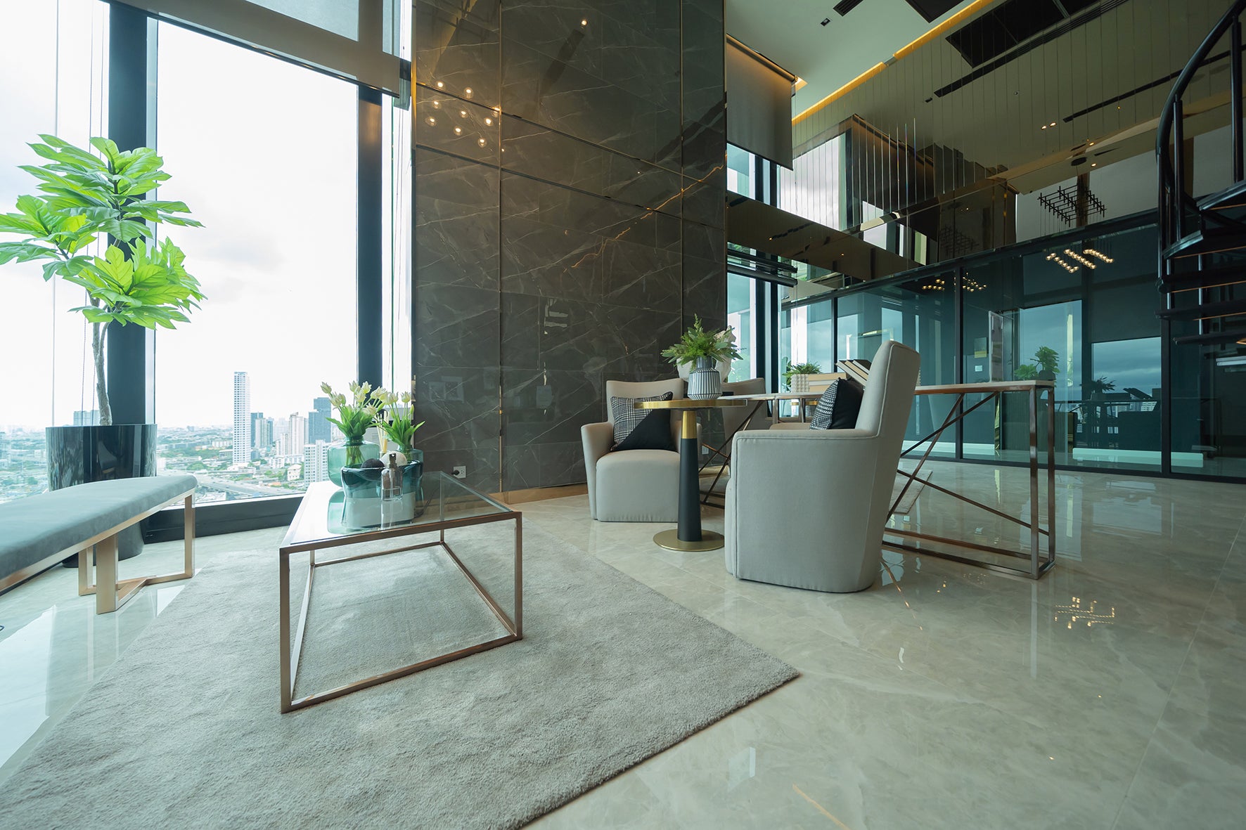 Lobby with floor to ceiling glass, seating area, large glossy tiles, and glass and metal furniture.