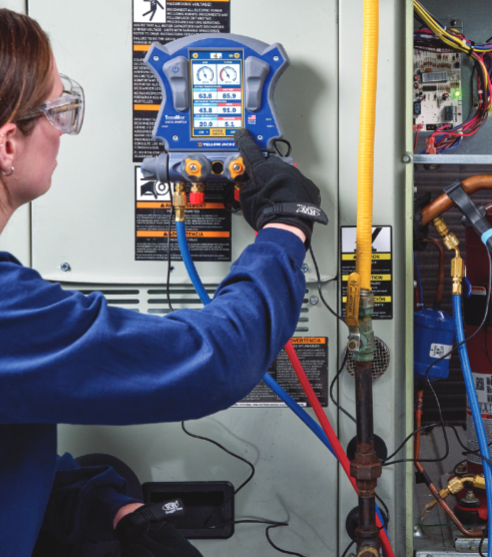 Person working on a piece of equipment with various hoses and tools in a technical setting