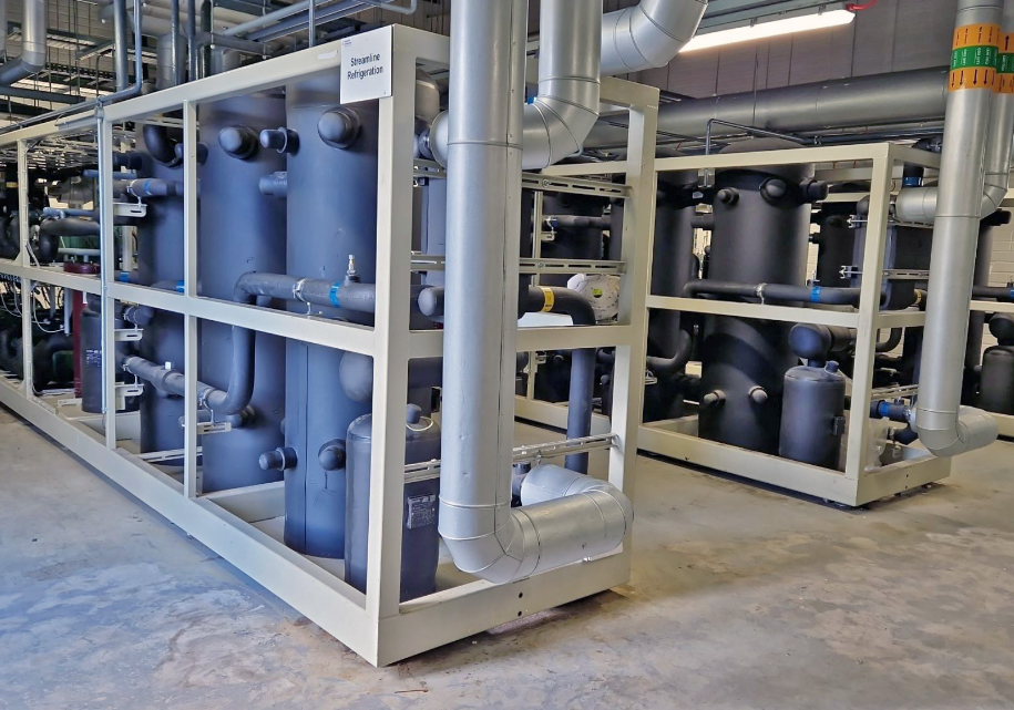 Industrial setting with blue cylindrical tanks and pipes in a room.